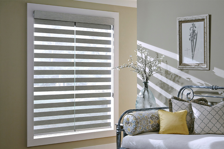 Find Practical and stylish window blinds for Raleigh homes at Sunburst. Gray blinds on a large window next to a couch.